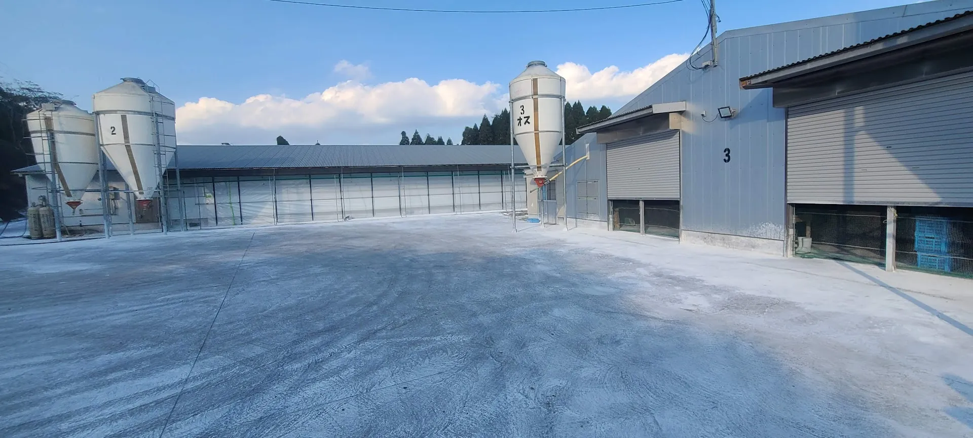 A poultry farm yard with feed silos and barns - the kind of livestock operation CropWatch monitors